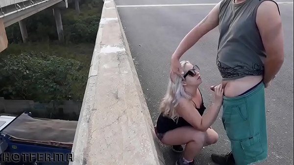 Nena rubia chupando a su pareja en un puente de